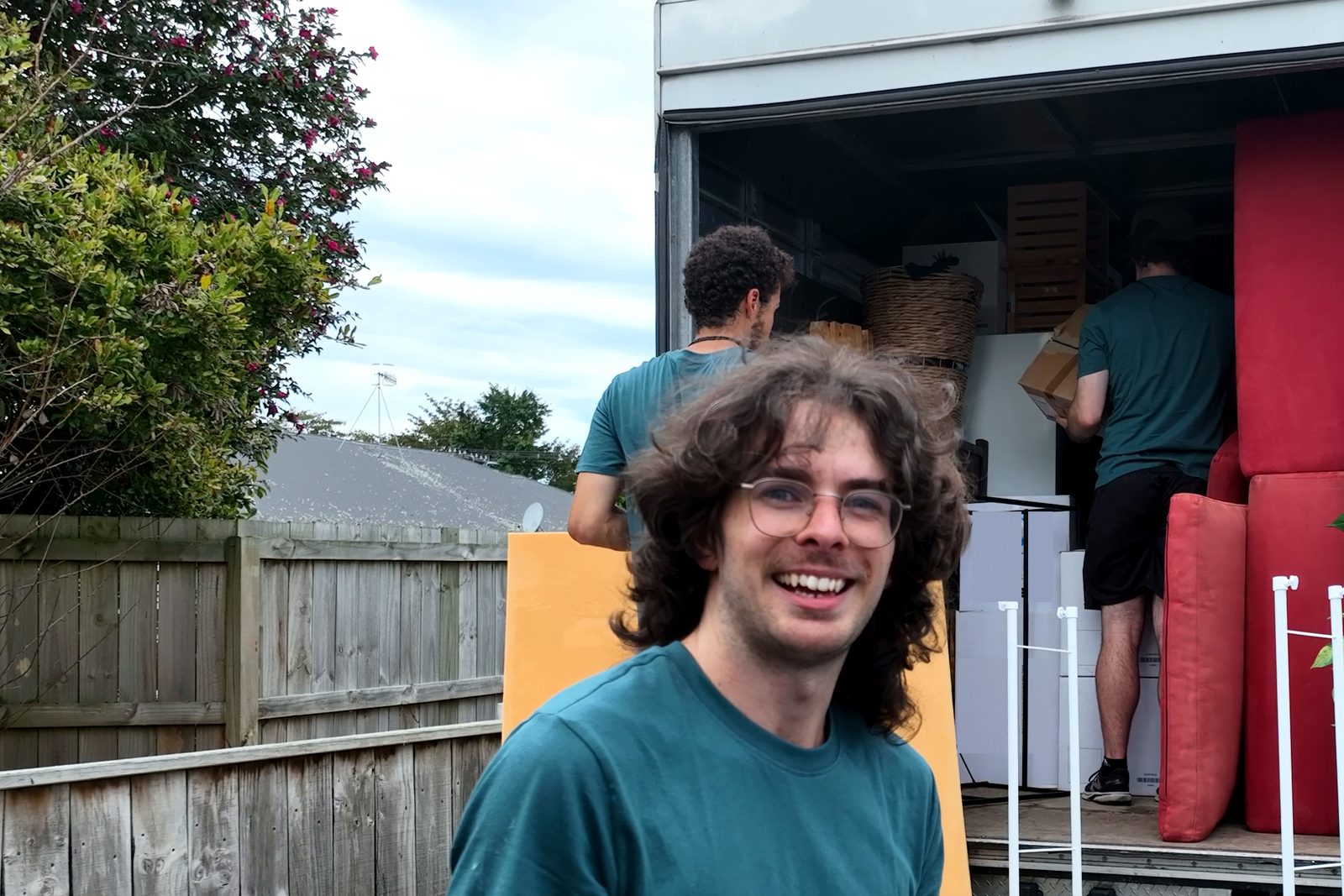 A smiling FLYTTE mover in front of the loaded truck